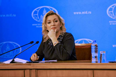 Maria Zacharova, en blond kvinna, sitter vid ett brunt skrivbord.