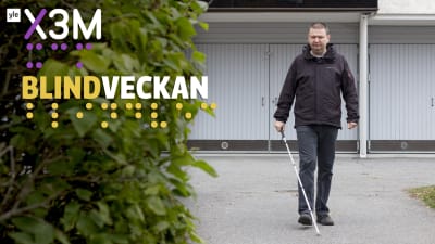 Andreas Kanto går mot kameran. Vi är utomhus och i bakgrunden syns ett höghus. Han går med vit käpp. 