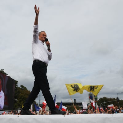 Den polska partiledaren Donald Tusk hälsar publiken vid en massdemonstration i Warszawa.