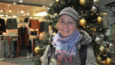 Sanna Sova står framför en julgran i köpcentret.