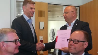 Ralf Bäckström, ombudsman på Aktia stiftelser i Österbotten, överräcker 50 000 euro till insamlingen. Markku Suoranta verksamhetsledare på Österbottens cancerförening tar emot. I förgrunden sitter Thomas Öhman och Christer Strömbäck från kampanjgruppen.