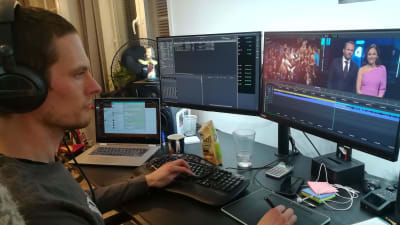 En man sitter framför tre datorskärmar och redigerar video.