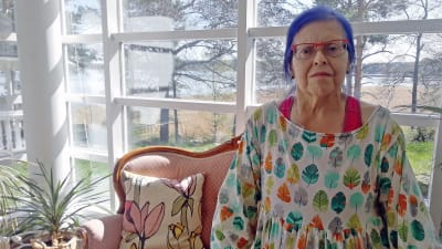 kvinna står framför soffa.