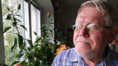 Författaren Lars Sund intill hibiskusen i hans kök i Uppsala. September 2018.