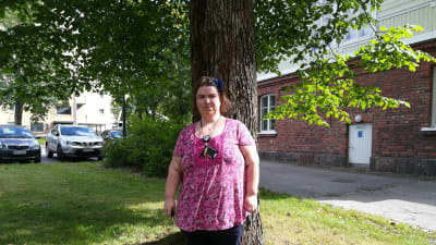 Närvårdare Emma Karlsson står framför ett träd. 