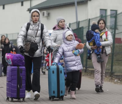 En grupp kvinnor med två barn går över gränsen till Polen.