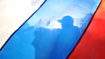 Pro-ryska aktivister bakom en rysk flagg på Krimhalvön i mars 2014