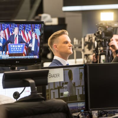 På golvet på börsen i Frankfurt. Mäklare följer med Donald Trumps tal i tv.