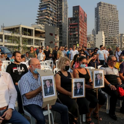 En grupp människor håller en tyst minut för offren i explosionen i Beirut.
