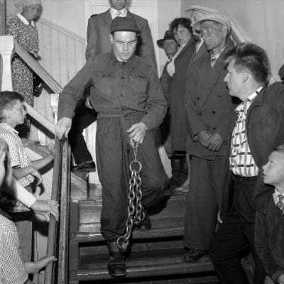 Mordmisstänkte Runar Holmström hämtas i bojor till rättegången i Heinävesi är 1960