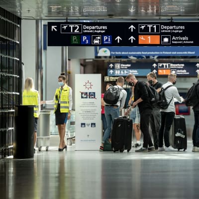 Personer med resväskor på Helsingfors-Vanda flygplats.