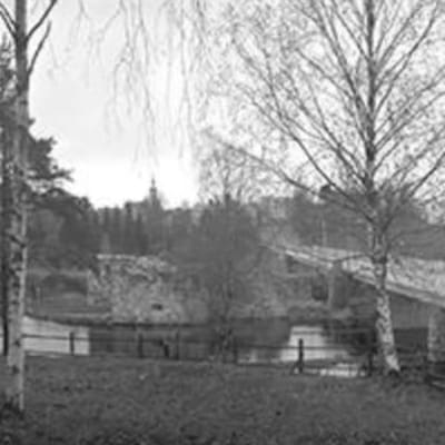 Mustavalkoisessa panoraamakuvassa Kajaaninjoki, linnan rauniot, Linnan silta ja alhaalla Ämmäkoski, keskellä takana kirkko.