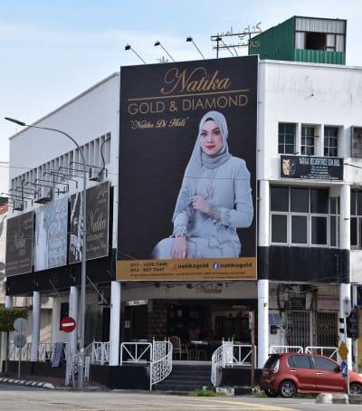Skylt med kvinna klädd i traditionell malaysisk muslimsk stil.