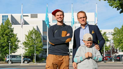 Elias Edström samt Oscar och Emil Taimitarha poserar framför Yleflaggor.