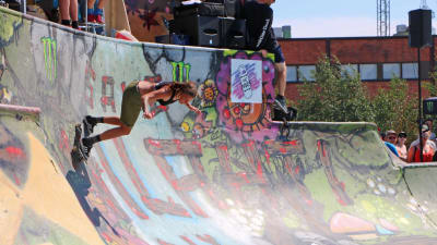 En ung kvinna åker rullbräda i en rullbrädspark (skatepark). 