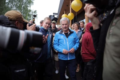 Sauli Niinistö står framför fotografer och journalister.