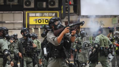 Polisen avfyrar tårgasgranater mot demonstranter i Hongkong på söndagen. 