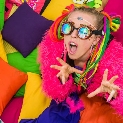 Vicky O'Neon poserar i färgranna kläder med färgade brillor.