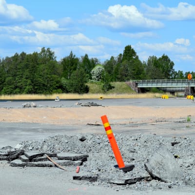 En sandgrop och en varningsstolpe i Norra hamnen i Ekenäs där hamnmagasinet stod tidigare. Hav i bakgrunden. En vacker sommardag.