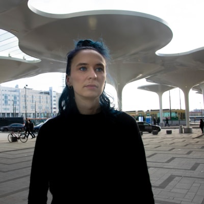 Emma Raunio utanför Triplas huvudingång med vita pelare i bakgrunden.