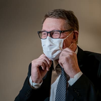 Valtiovarainministeri Matti Vanhanen kohentaa kasvomaskiaan.