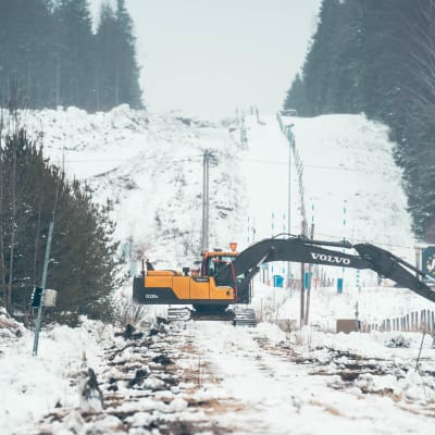 Kaivuri tekee töitä tulevan raja-aidan kohdalla.