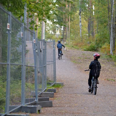 Tre barn cyklar förbi Vårberga utbildningscentrum.