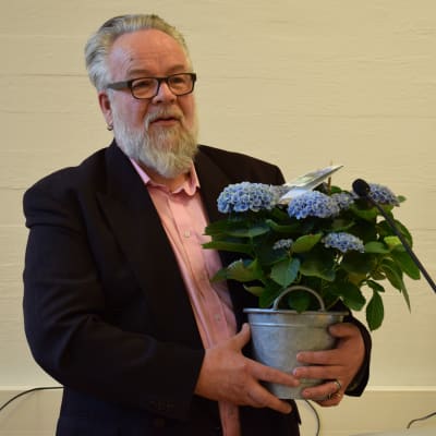 Veijo Lücke med blommor i famnen.