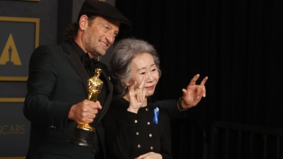 Troy Kotsur och Youn Yuh-jung står tillsammans på scenen medan Kotsur håller i sin Oscarsstatyett.