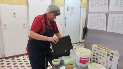 Kosthållschef Agneta Lindroos packar ner en modell av Raseburgaren.