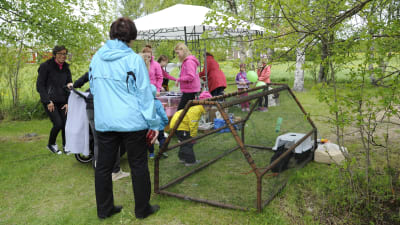 Människor tittar på kaniner och står under tält på byadagen i Parhalahti