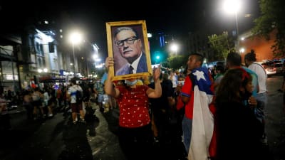 En anhängare till Boric bar på ett Allende-porträtt under firandet i Santiago. 