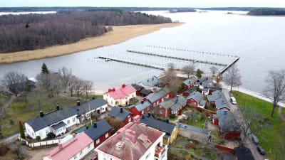 Flygbild över Barckens udde i Ekenäs. Man kan se en del av Gamla stans hus och bryggorna och pålar vid vattnet.