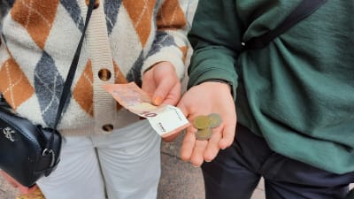 Två kvinnor har 14 euro 50 cent i handen.