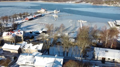 Vy över Ekenäs gästhamn i vinterskrud. Där det växer mest träd finns en tom tomt där det finns planer på att bygga ett hotell.