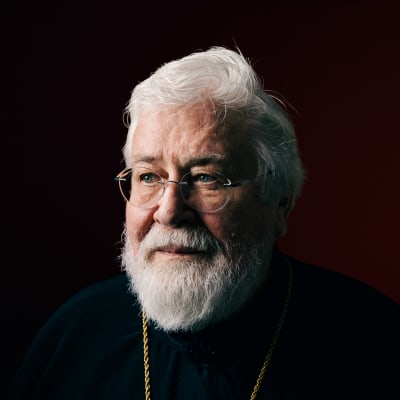 Arkkipiispa Leo tummanpunaista taustaa vasten.