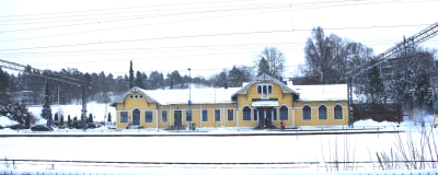 Ett gult trähus som är järnvägsstationen i Karis.