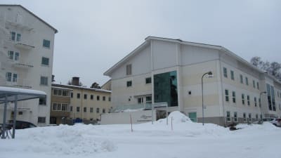 Vita våningshus vid Raseborgs sjukhus i ett vinterlandskap.