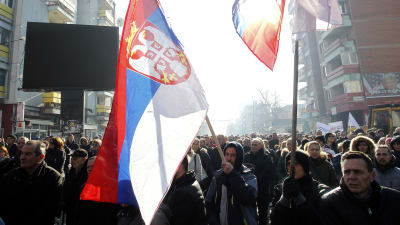 Serber i Kosovo demonstrerar med serbiska flaggor och symboler på gata i staden Mitovica.