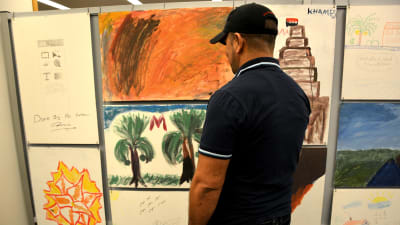 "Mohammed" vill vara anonym. Här står han framför den tavla han målat.