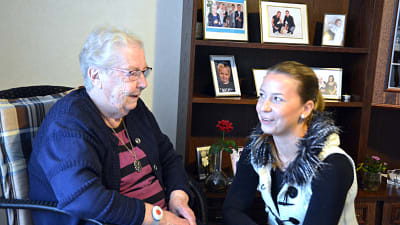 Äldre person på serviceboendet Solglimten diskuterar med yngre person.