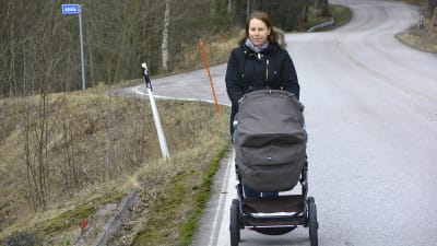 Linda Sundberg knuffar sonen Rufus i barnvagn längs Vålaxvägen