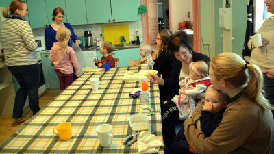 Mammor och barn äter vid Pernå församlings klubb i prästgården.