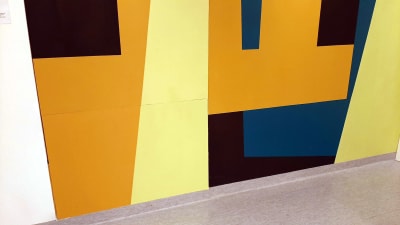 Rektangulära figurer i olika färger på en vägg.