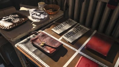 Nahkasalkku, kirjoja, piiras, sanomalehtiä ym. teatterirekvisiittaa Agatha Christien näytelmästä The Mousetrap