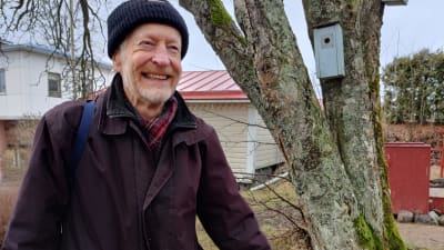En man i mössa och jacka, han skrattar. Han heter Mikael Wahlforss.