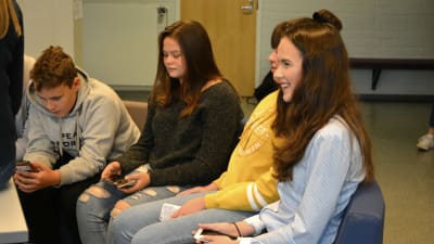 Niorna Alex Östman, Amanda Nyby, Matilda Bengts och Emilia blom sitter i en soffa och ser på sina telefoner.