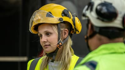 Porträttfoto av kvnna i reflexväst och skyddshjälm