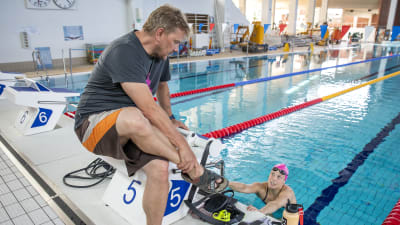 Valmentaja Marko Malvela ja uimari Fanny Teijonsalo juttelevat altaan reunalla harjoituksissa.