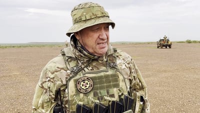 Jevgenij Prigozjin tittar åt sidan klädd i militärutrustning.